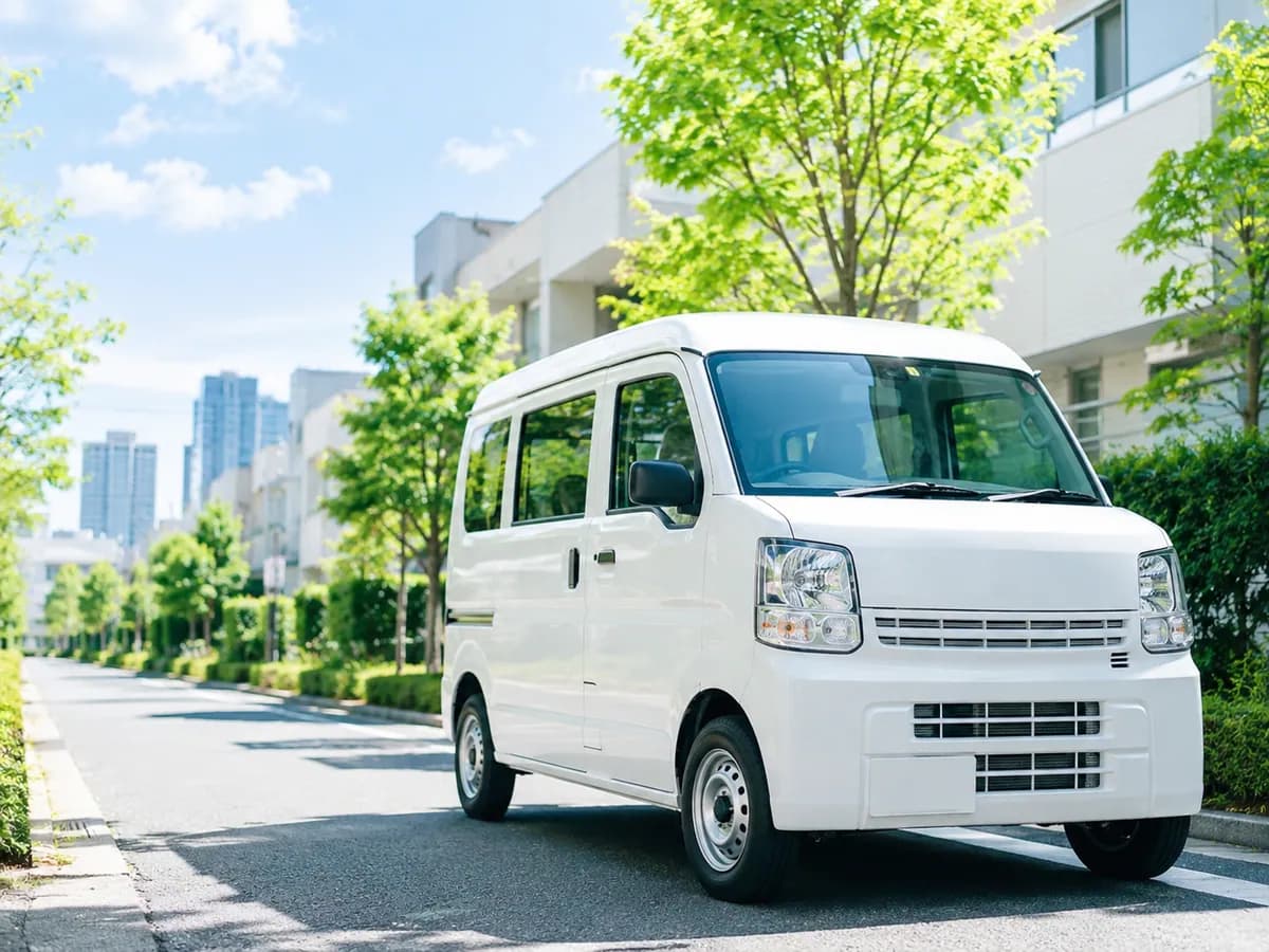 船橋市の並木道を走る株式会社ウィランの軽貨物配送車